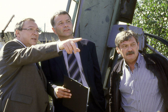 Polizeiruf 110 "Vollgas": Auf dem Schrottplatz werden gef&auml;lschte Autoersatzteile vernichtet. Oberzollrat Kroner (Thomas R&uuml;hmann) erkl&auml;rt den Kommissaren Schm&uuml;cke (Jaecki Schwarz) und Schneider (Wolfgang Winkler) das Verfahren.