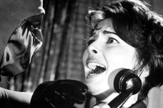 Valerie Howett (Karin Dor) wird von dem maskierten Bogenschützen beim Telefonat überrascht und bedroht.