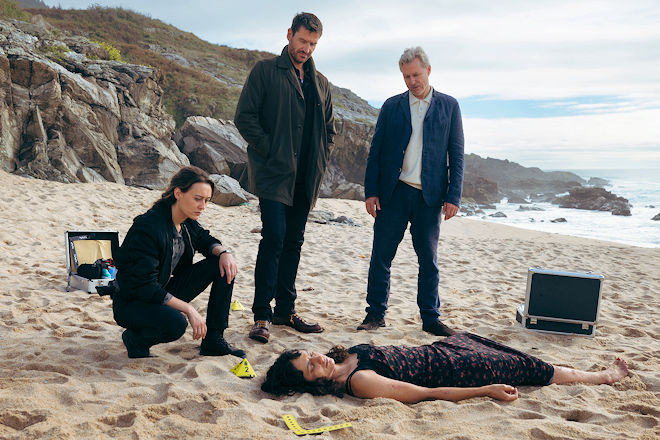 Frauenleiche an der Atlantikküste: Mercédes Navarro (Mercedes Müller, li.), David Acosta (Michael Epp) und Adrían Martinéz (Dirk Borchardt, re.) schauen sich die tote Sofía Serrano (Sylvana Seddig, unten) genauer an.