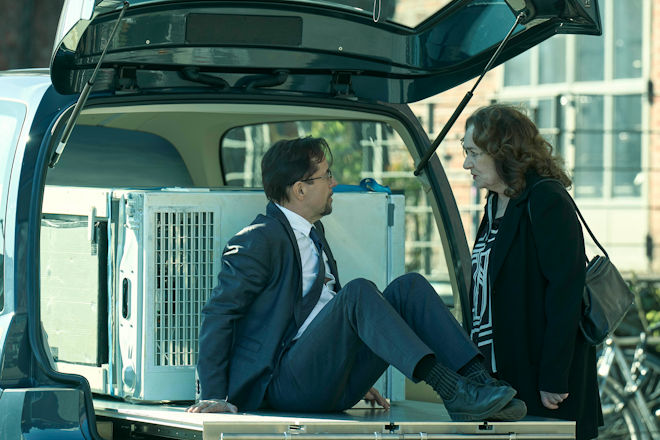 Münster-Tatort "Die Erfindung des Rades": Während Prof. Karl Friedrich Boerne (Jan Josef Liefers, l.) sich entschieden hat, den Abtransport der tiefgefrorenen Leiche persönlich zu begleiten, möchte Staatsanwältin Wilhelmine Klemm (Mechthild Großmann) von ihm wissen, welcher der Hobrecht-Männer in der Kühltruhe liegt