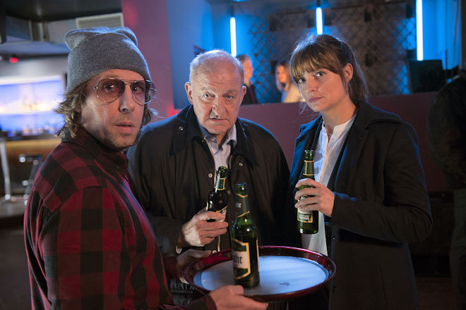 Ekki (Oliver Korittke, l.) gibt sich als Barkeeper aus, um im Club "Ground Control" undercover zu ermitteln. Doch Wilsberg (Leonard Lansink, M.) üterund Alex (Ina Paule Klink, r.) sind skeptisch, ob die Tarnung hält.