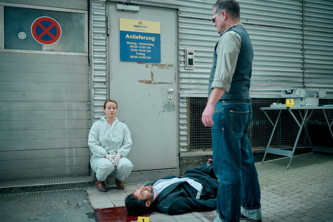 Dr. Theresa Wolff (Nina Gummich, l. ) kennt das Opfer Gábor Kértesz (Deniz Arora, M.), dessen Tod sie nun untersuchen soll. Hauptkommissar Bruno Lewandowski (Aurel Manthei, r.) wundert sich über das daraus resultierende merkwürdige Verhalten seiner Kollegin.