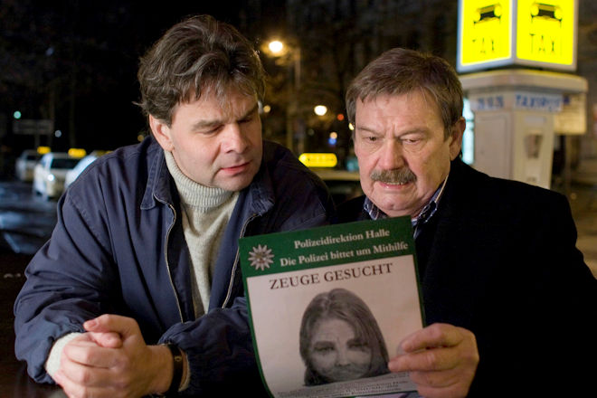 Kriminalhauptkommissar Herbert Schneider (Wolfgang Winkler, rechts) verteilt am Imbiss Phantombilder unter den Taxifahrern.