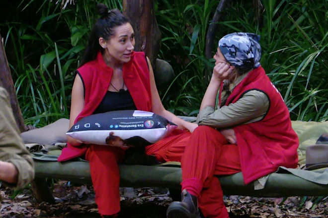RTL Dschungelcamp 2026: Samira (l.) konfrontiert Eva (r.) mit einer auf ihr Kissen gedruckten Nachricht und l&ouml;st damit einen beispiellosen Eklat um Verrat und zerst&ouml;rte Familientr&auml;ume im australischen Busch aus.