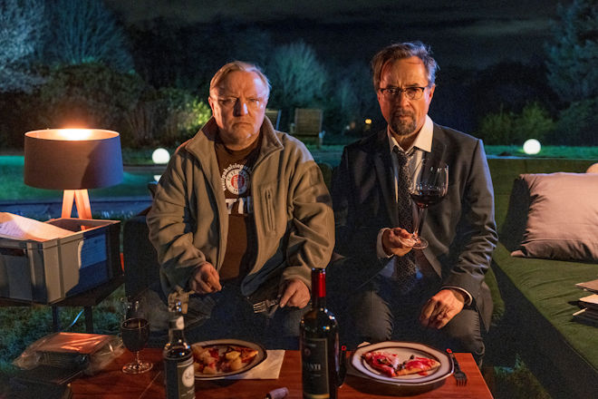 M&uuml;nster-Tatort "Man stirbt nur zweimal": Bei TK-Pizza und Rotwein sinnieren Hauptkommissar Thiel (Axel Prahl, l.) und Dr. Karl-Friedrich Boerne (Jan Josef Liefers, r.) &uuml;ber die m&ouml;glichen Szenarien des t&ouml;dlichen Unfalls nach dem Streit zwischen Doreen Pr&auml;torius und Oskar Weintraub.