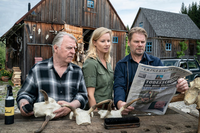Alt-Förster Georg Bergelt (Andreas Schmidt-Schaller, l.), Försterin Saskia Bergelt (Teresa Weißbach, M.) und Kommissar Robert Winkler (Kai Scheve, r.) sind erstaunt über die Details in der Berichterstattung.