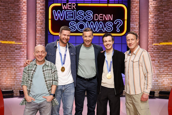 Moderator Kai Pflaume (M.) und seine Rateteam-Kapit&auml;ne Bernhard Ho&euml;cker (l.) und Wotan Wilke M&ouml;hring (r.) begr&uuml;&szlig;en heute (31.03.2026) bei "Wer wei&szlig; denn sowas?" den zweifacher Olympiasieger und f&uuml;nfmaliger Weltmeister im Bobfahren Johannes Lochner (2.v.l.) sowie den Skisprung-Olympiasieger Philipp Raimund (2.v.r.).