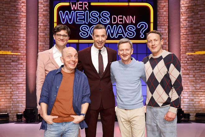 Moderator Kai Pflaume (M.) und seine Rateteam-Kapit&auml;ne Bernhard Ho&euml;cker (v.l.) und Wotan Wilke M&ouml;hring (r.) begr&uuml;&szlig;en heute (13.04.2026) bei "Wer wei&szlig; denn sowas?" Bodo Wartke (h.l.) und Michael Kessler (2.v.r.).