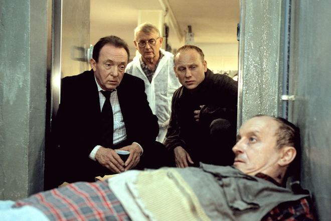 Leipzig-Tatort "Sonnenfinsternis": (V.l.) Hauptkommissar Ehrlicher (Peter Sodann), Walter (Walter Nickel) und Hauptkommissar Kain (Bernd Michael Lade) betrachten den Toten im Fahrstuhl.